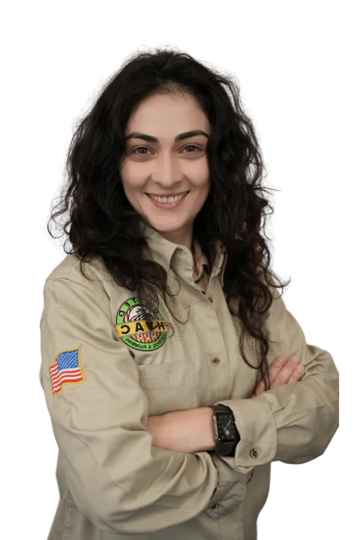 Fariza, a Home Advisor at United HVAC Electric & Plumbing, smiling confidently with arms crossed. She is wearing a beige company uniform with an American flag patch and the United HVAC Electric & Plumbing logo on the left side.
