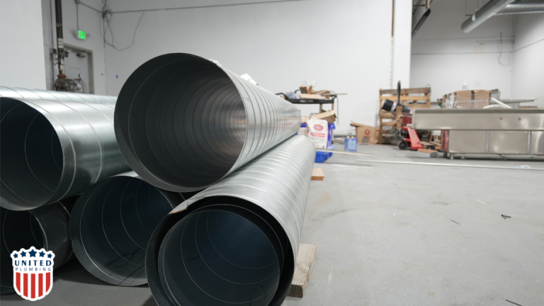 Industrial HVAC air ducts stacked on the floor in a commercial facility, ready for installation by United HVAC electrical & plumbing. 