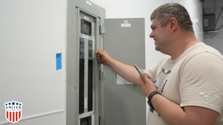 United Plumbing technician inspecting and testing a circuit breaker panel in a residential or commercial setting
