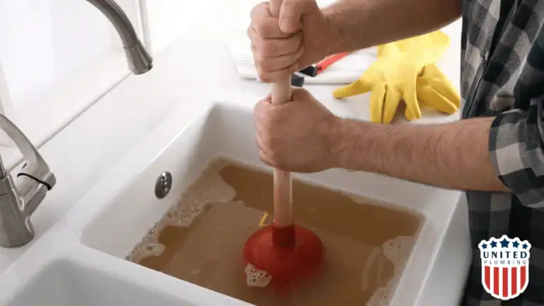 “Homeowner using a red plunger on a kitchen sink full of dirty water to clear a clogged drain.”
