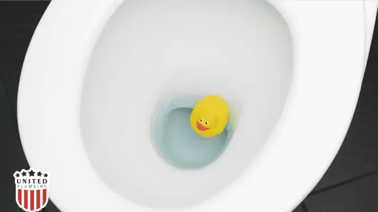 Top view of a toilet bowl with a yellow rubber duck inside, symbolizing objects that cause toilet clogs.