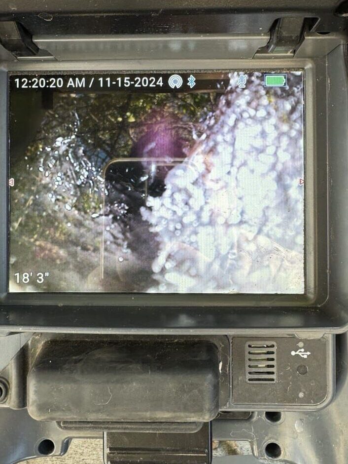 Sewer inspection camera monitor showing video footage from inside a sewer line